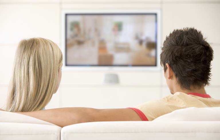 Couple in living room watching television